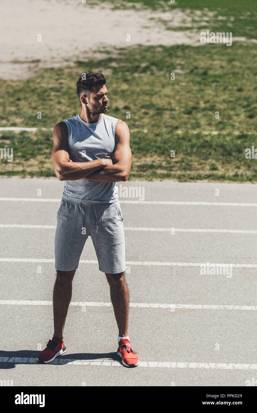 serious young man with crossed arms on running track Stock Photo - Alamy