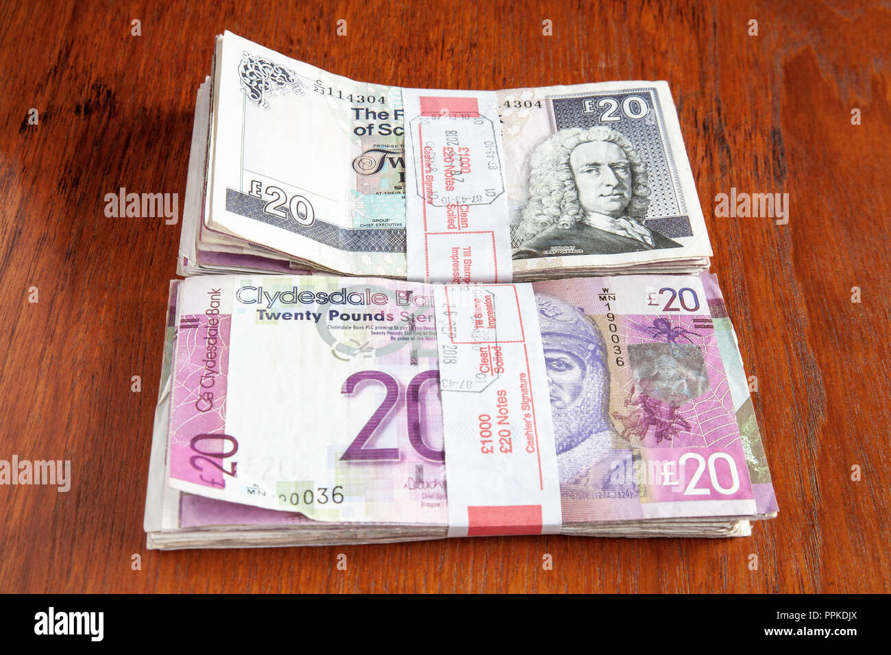 Money left on the table. £2000 sterling in used Scottish £20 banknotes, from the Royal Bank of Scotland and the Clydesdale Bank. Shallow dof. Stock Photo