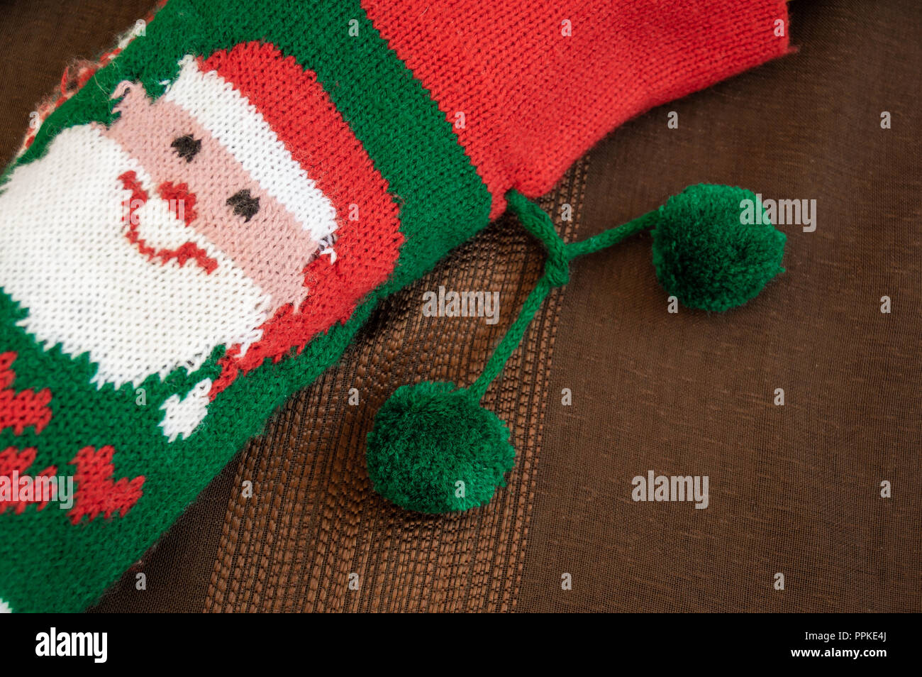 Colorful christmas sock with drawing of Santa Claus to fill with gifts. Sock with decoration and christmas motifs, traditional in these holidays. Stock Photo