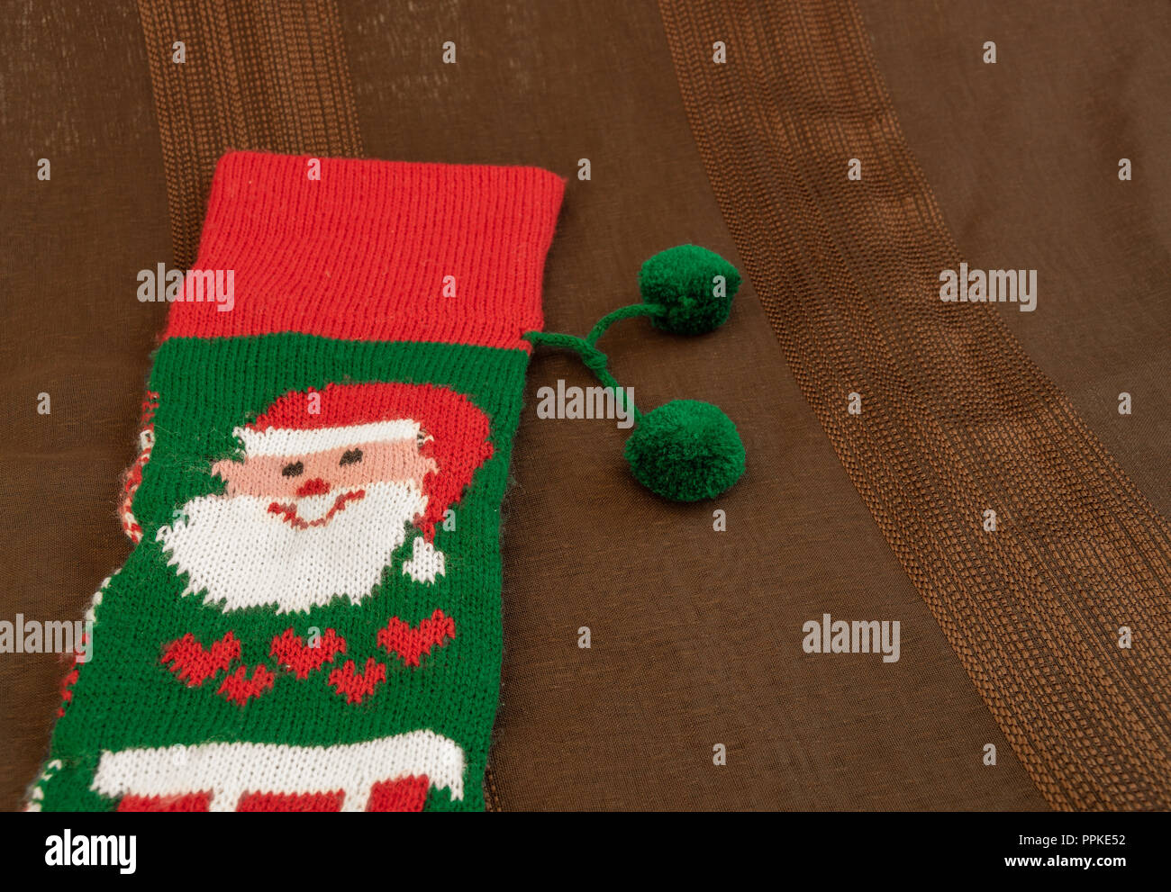 Colorful christmas sock with drawing of Santa Claus to fill with gifts. Sock with decoration and christmas motifs, traditional in these holidays. Stock Photo