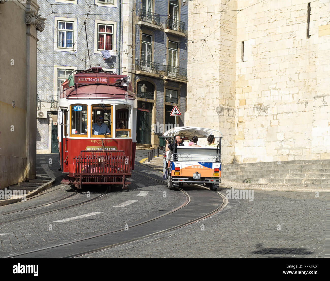 LISBON, PORTUGAL - August 31, 2018: Tourists visit  the Lisbon with the red tram and tuk-tuk. Alfama next to the Se Cathedral Stock Photo