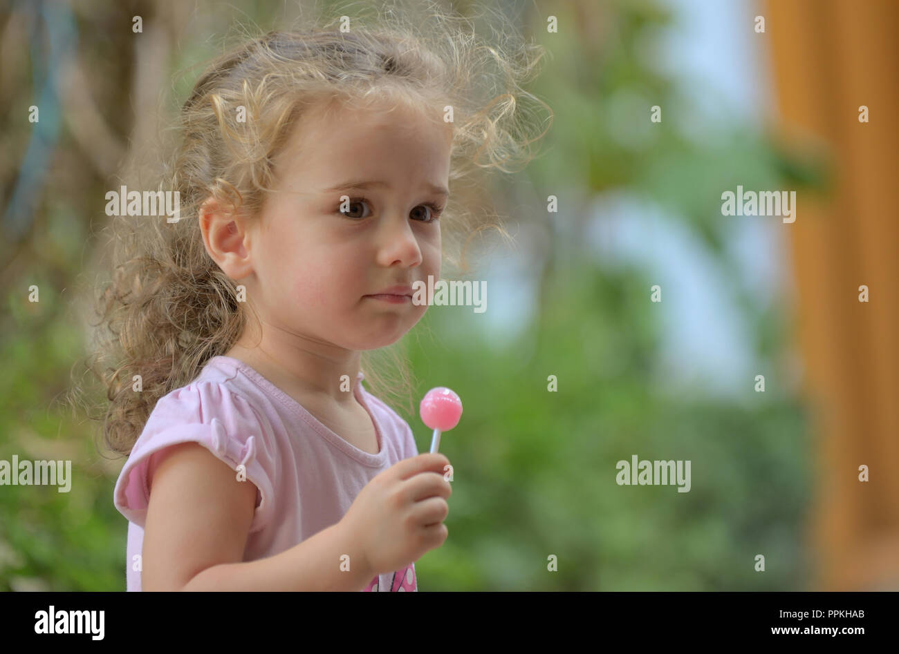 Little girl with lollipop in nature Stock Photo
