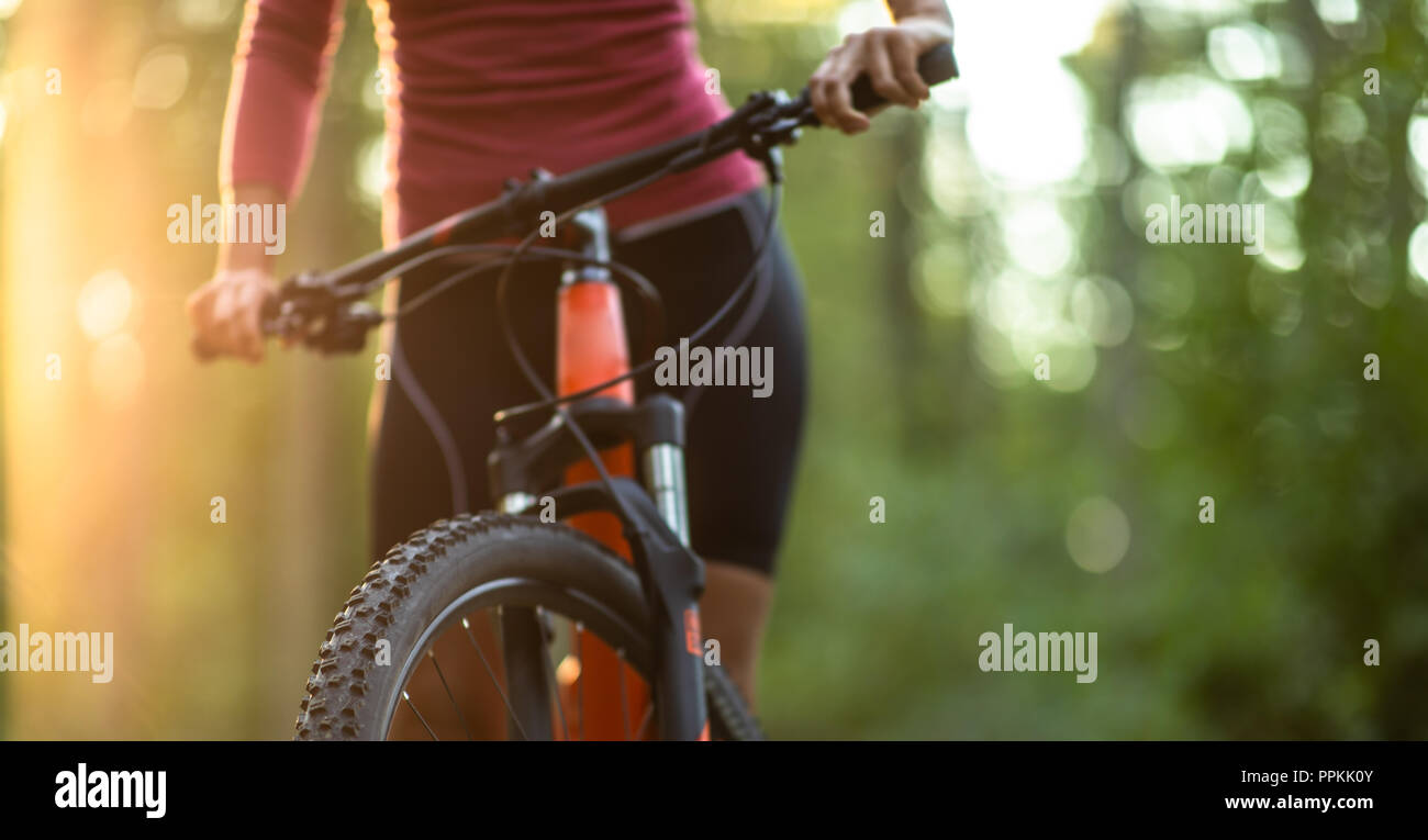 Pretty, young woman biking on a mountain bike enjoying healthy active lifestyle outdoors in