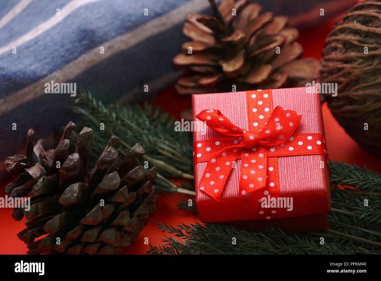 Red gift boxes and pine cones on red background Stock Photo