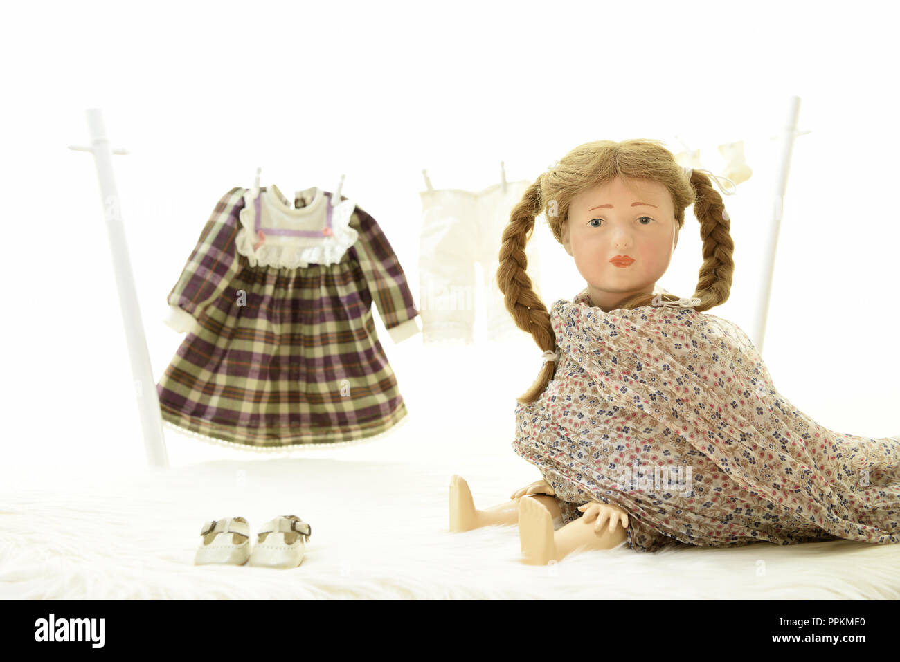 Doll Elise is trying her cloth (Germany). Puppe Elise hat Wäsche zum trocknen auf eine Wäscheleine gehängt. Stock Photo