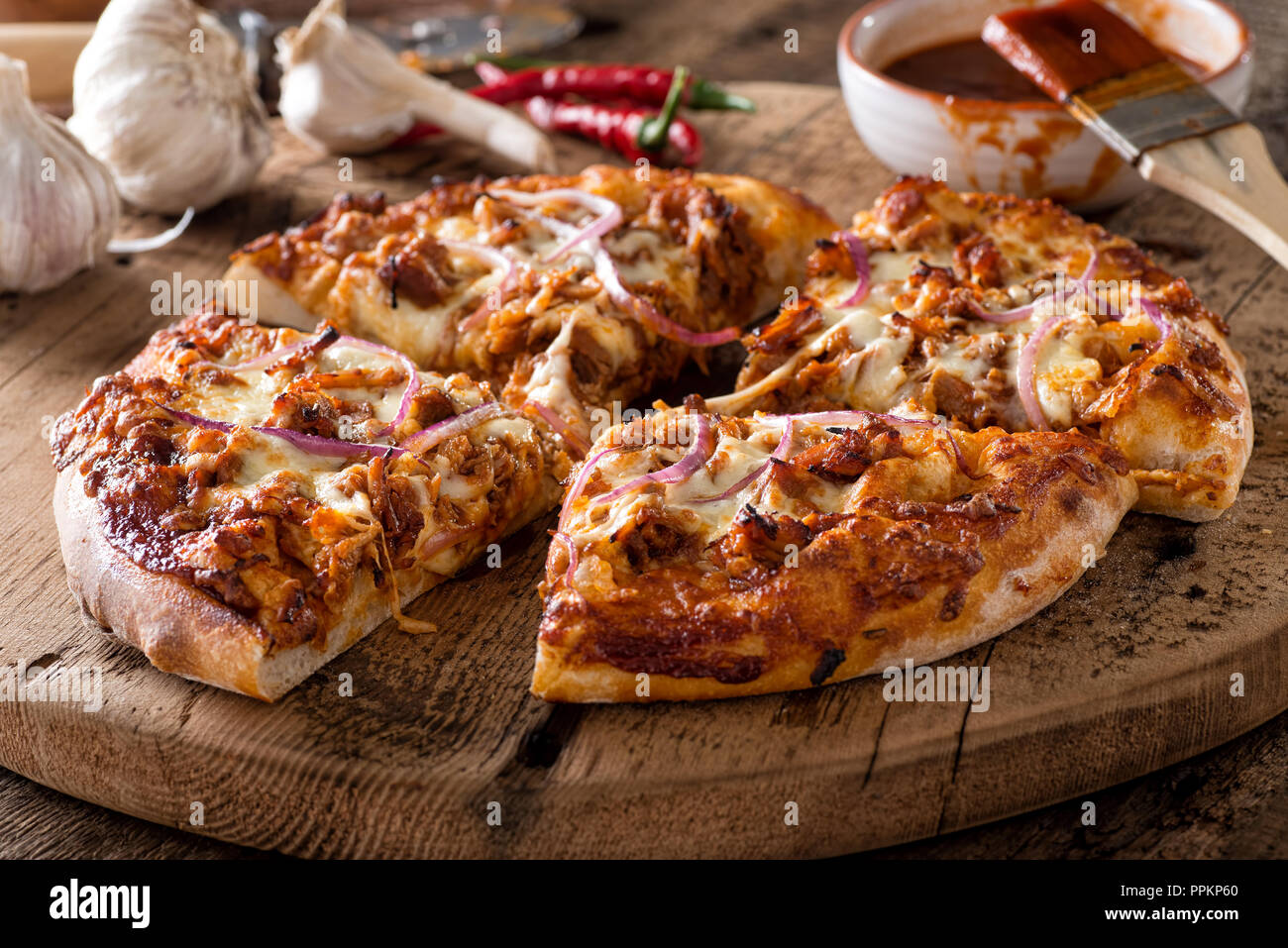 A delicious rustic homemade pizza with bbq pulled pork and red onion. Stock Photo