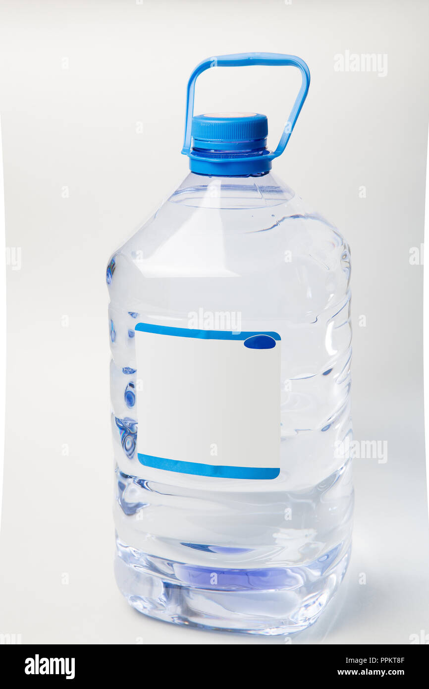 Big plastic bottle with water on the table over bright kitchen backgroung.  Bottle of clear transarent water in a blue color cap and handle closeup  Stock Photo - Alamy