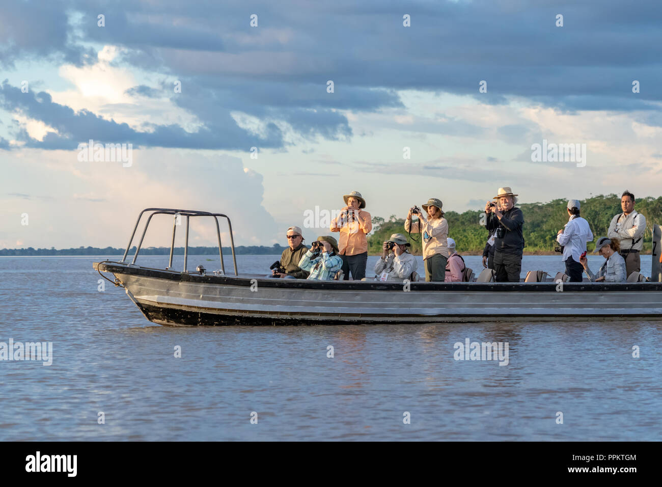 Pacaya Samiria Reserve, Peru, South America.  Tourists in a skiff watching for dolphins in the Maranon river, an Amazon tributary. Stock Photo