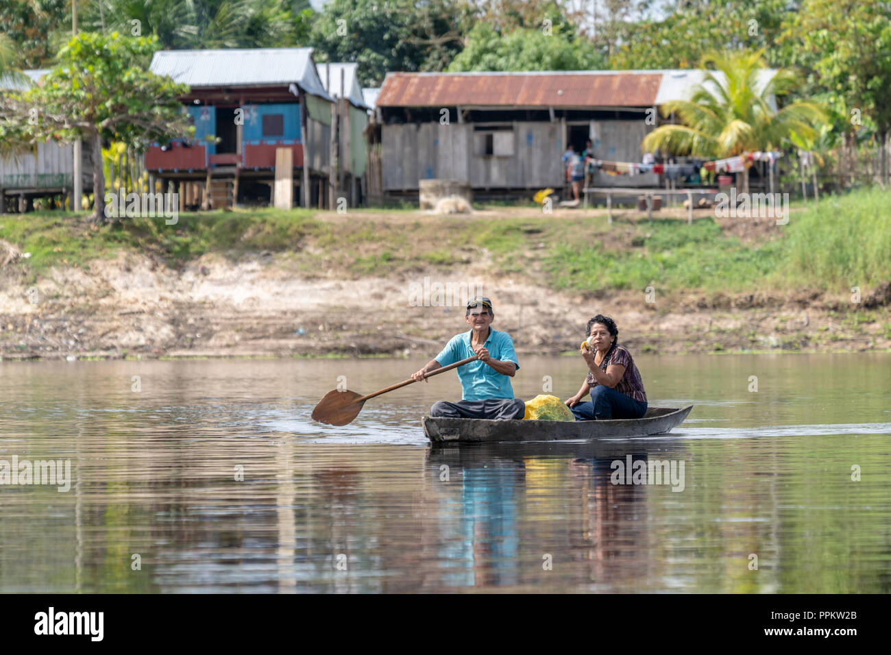 Pacaya Samiria Reserve, Peru, South America.  Native Peruvians paddling a dugout canoe.  (For editorial use only) Stock Photo