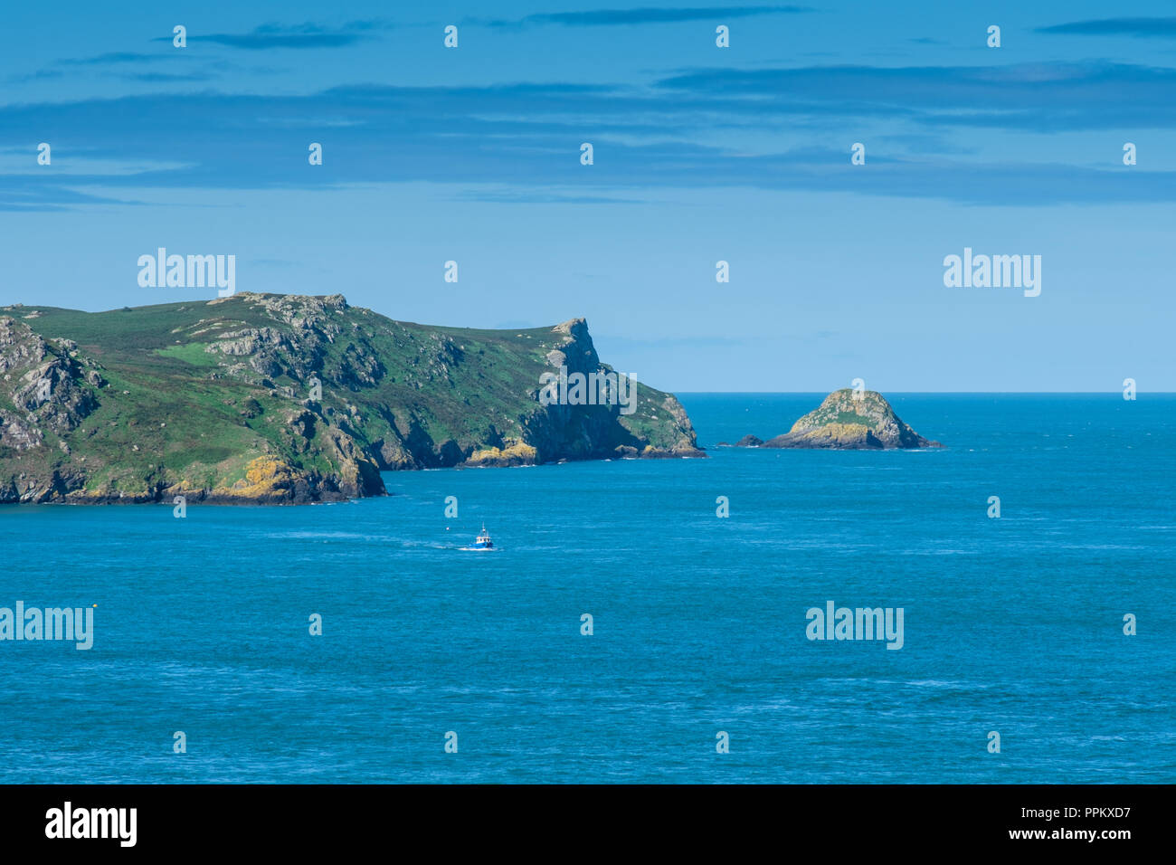 Tourist boat returning from Skomer Island, with the Garland Stone in the background, seen from Martin's Haven, near Marloes, Pembrokeshire Stock Photo
