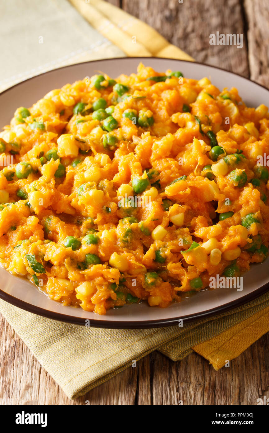 Delicious Kenyan food - Irio sweet potato with green peas and corn close-up on a plate on the table. vertical Stock Photo