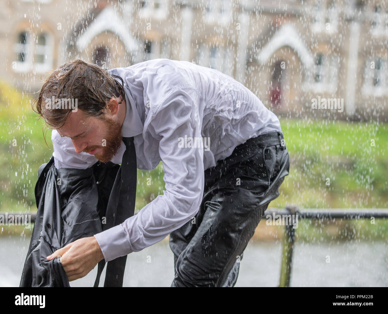 A man in a suit caught in a very heavy rain shower Stock Photo Alamy