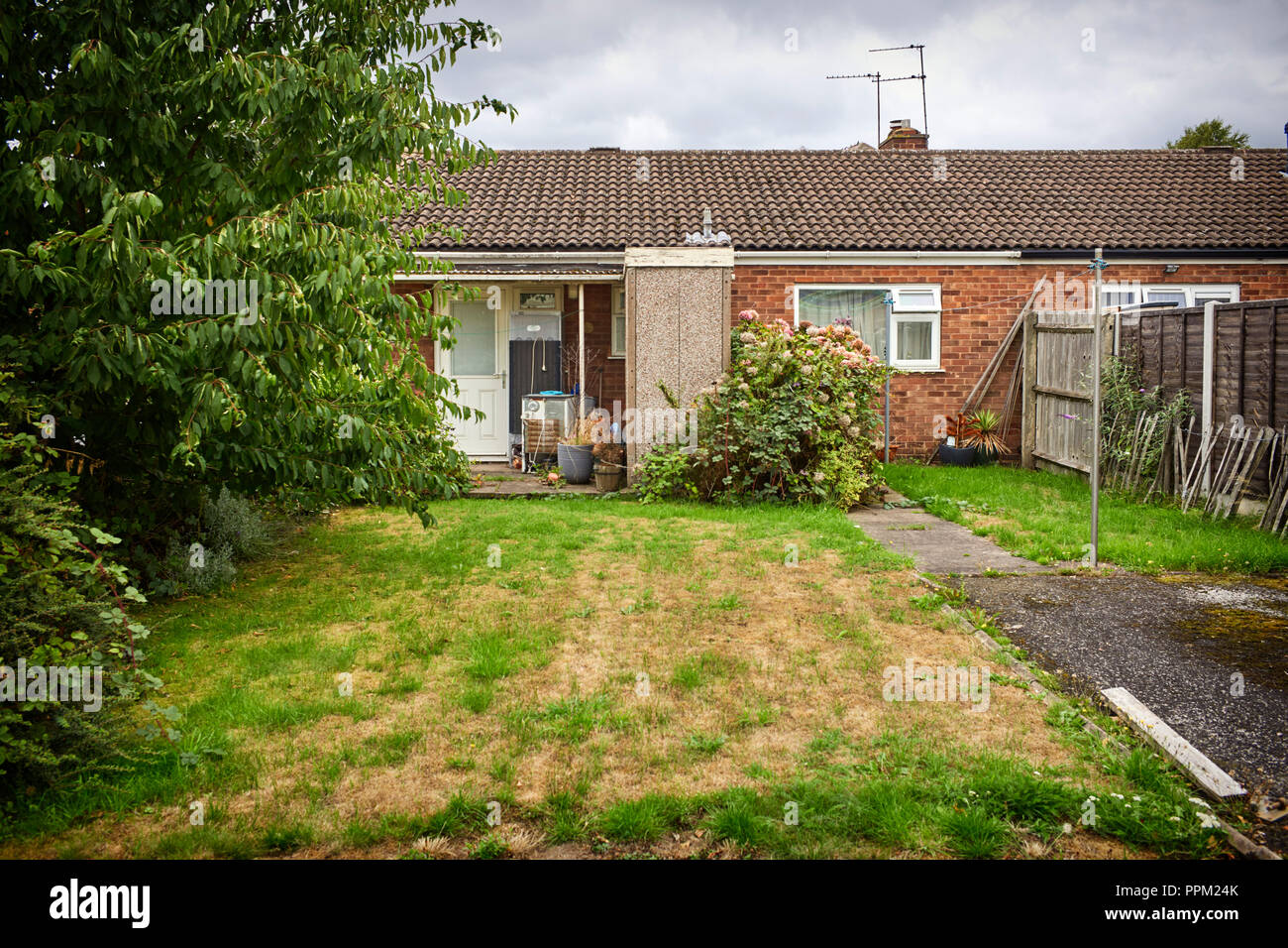 Bungalow with rubbish with old fridges outside and a badly dried out front lawn in Rugeley, Staffordshire Stock Photo