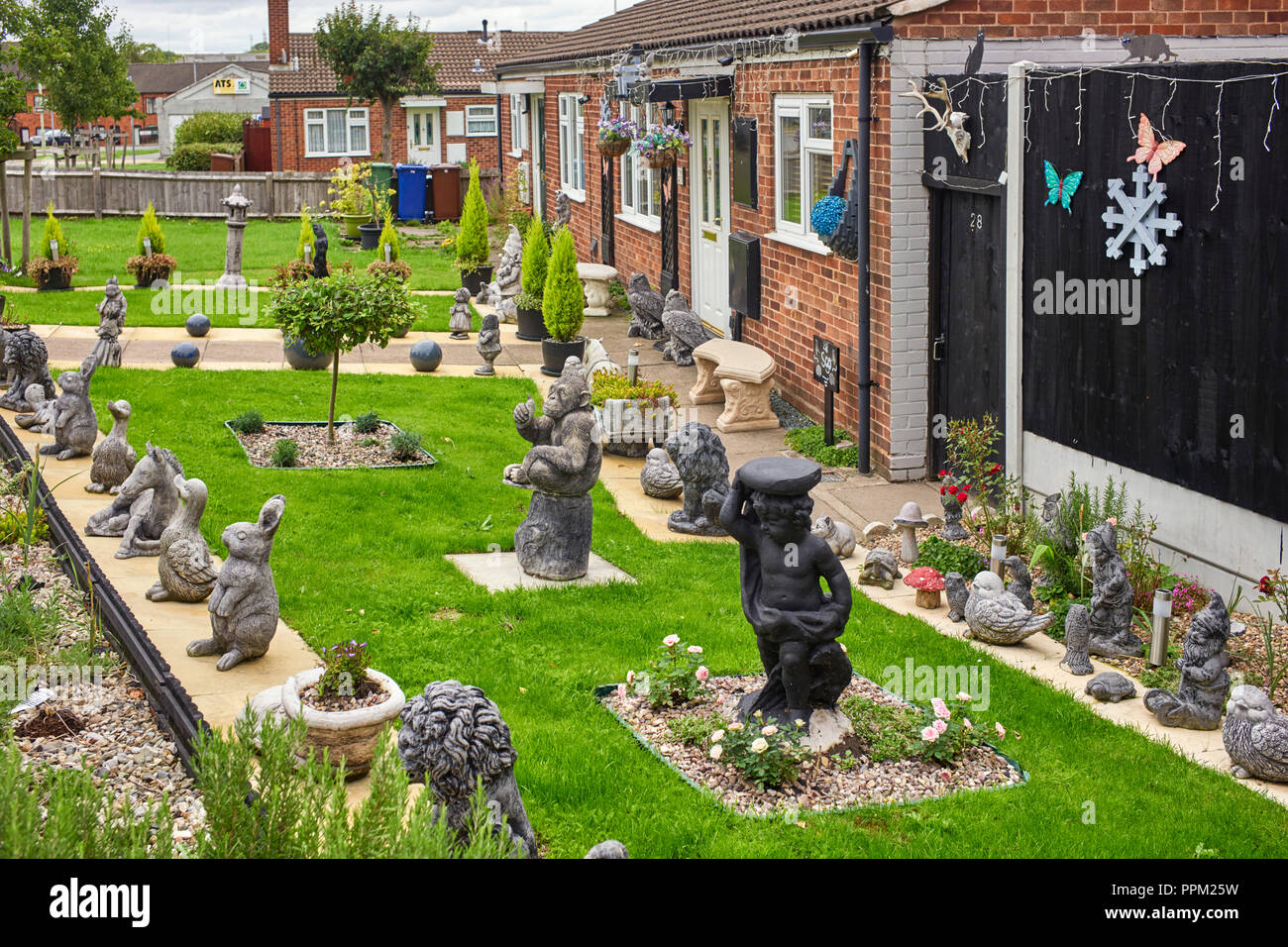 Excessive number of garden ornaments in the front garden of a bungalow in Rugeley, Staffordshire Stock Photo