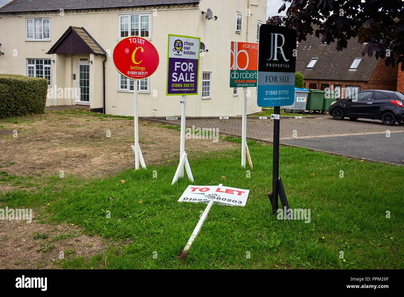 Five different estate agents signs and one fallen down in Rugeley, Staffordshire Stock Photo