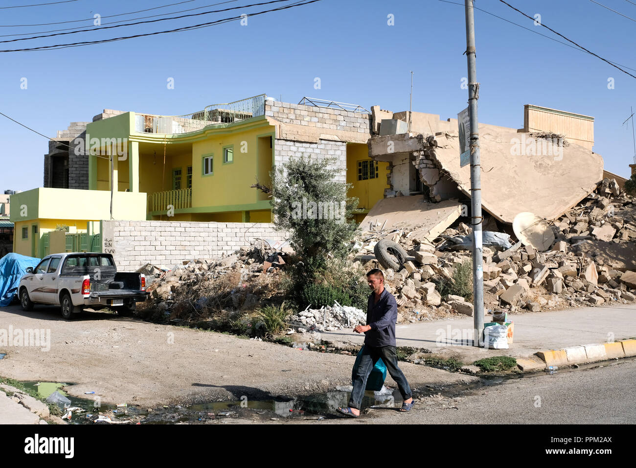 Destroyed (right) and rebuilt house in Bashiqua, Iraq, Kurdistan - Zerstörtes und wiederaufgebautes Haus im Ort Bashiqua, Irak Kurdistan Stock Photo