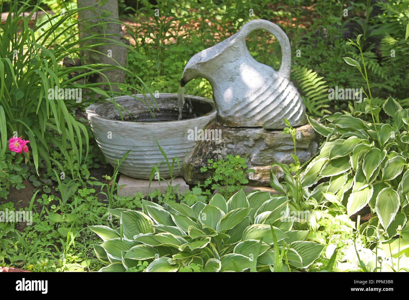 Outdoor urn with flowing water into bowl Stock Photo