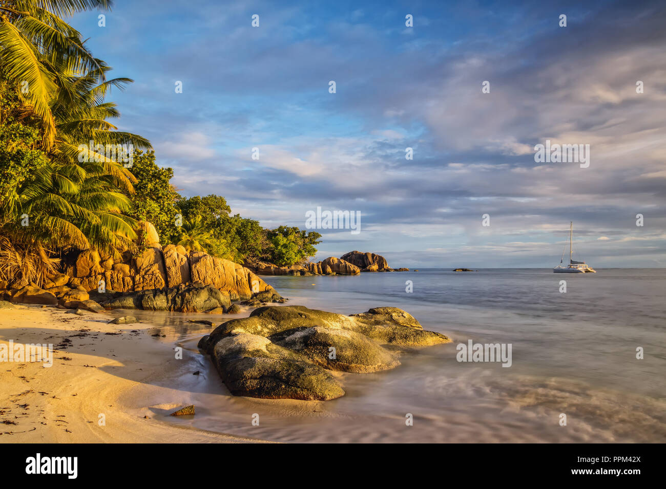A golden sunset at the Anse Bateau on Praslin creates a wonderful and tropical atmosphere. Stock Photo