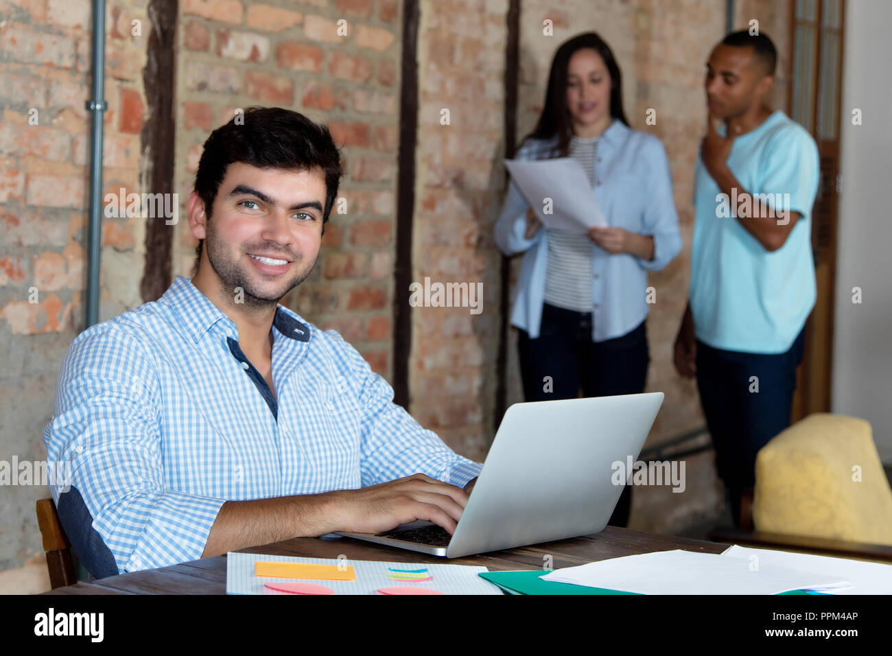 Smart caucasian software developer with computer at office of start up company Stock Photo