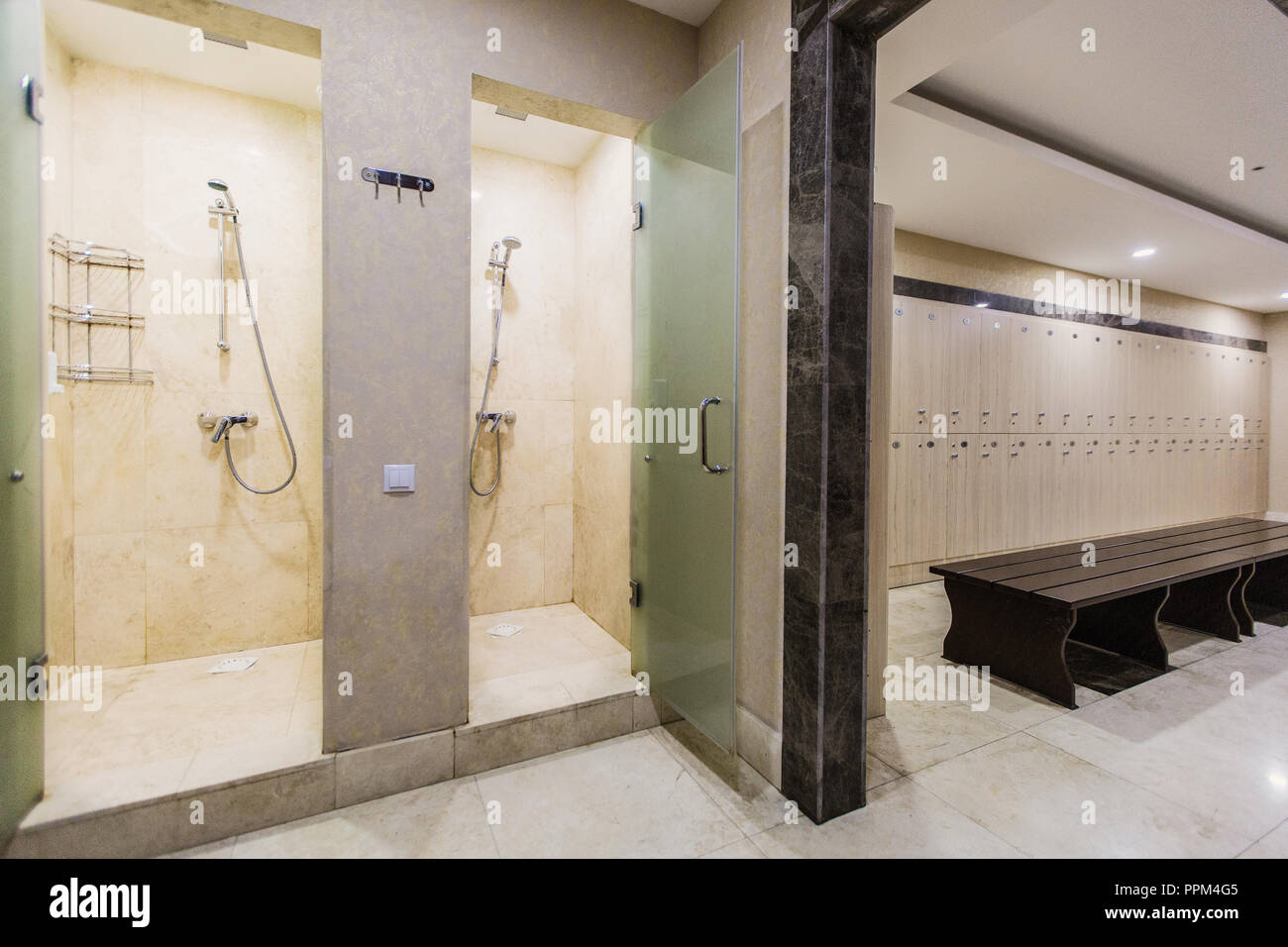 Cloakroom in the hotel or gym, wooden wardrobes, bench and shower rooms Stock Photo