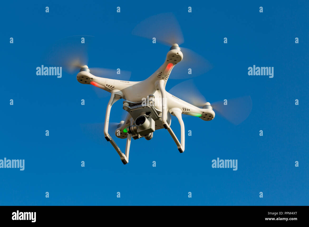 Niedernhausen, Germany, April 9th, 2017, Quadcopter drone DJI Phantom flying into blue sky Stock Photo