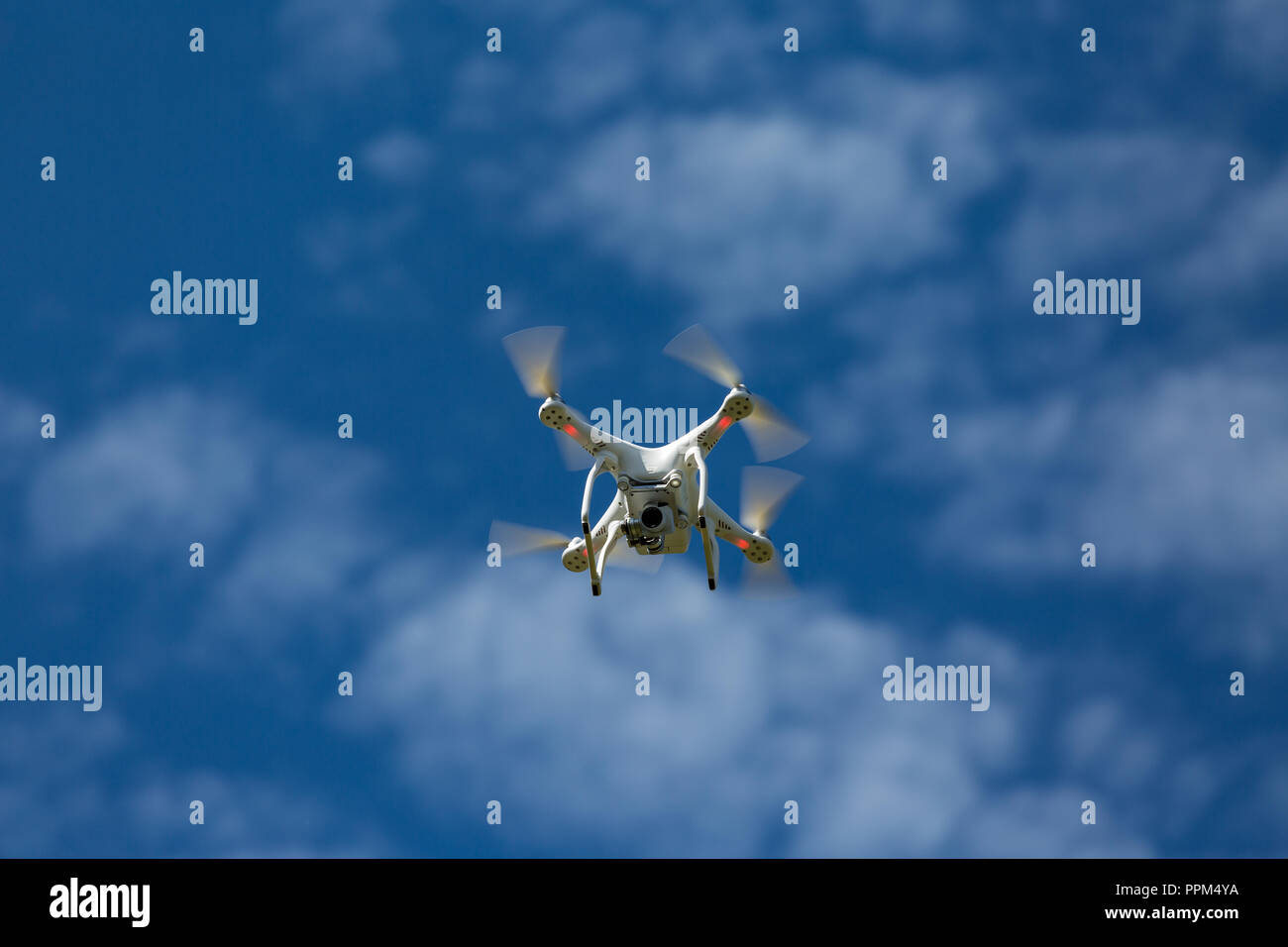 Niedernhausen, Germany, Juner 06th, 2017, Quadcopter drone DJI Phantom flying into blue cloudy sky Stock Photo