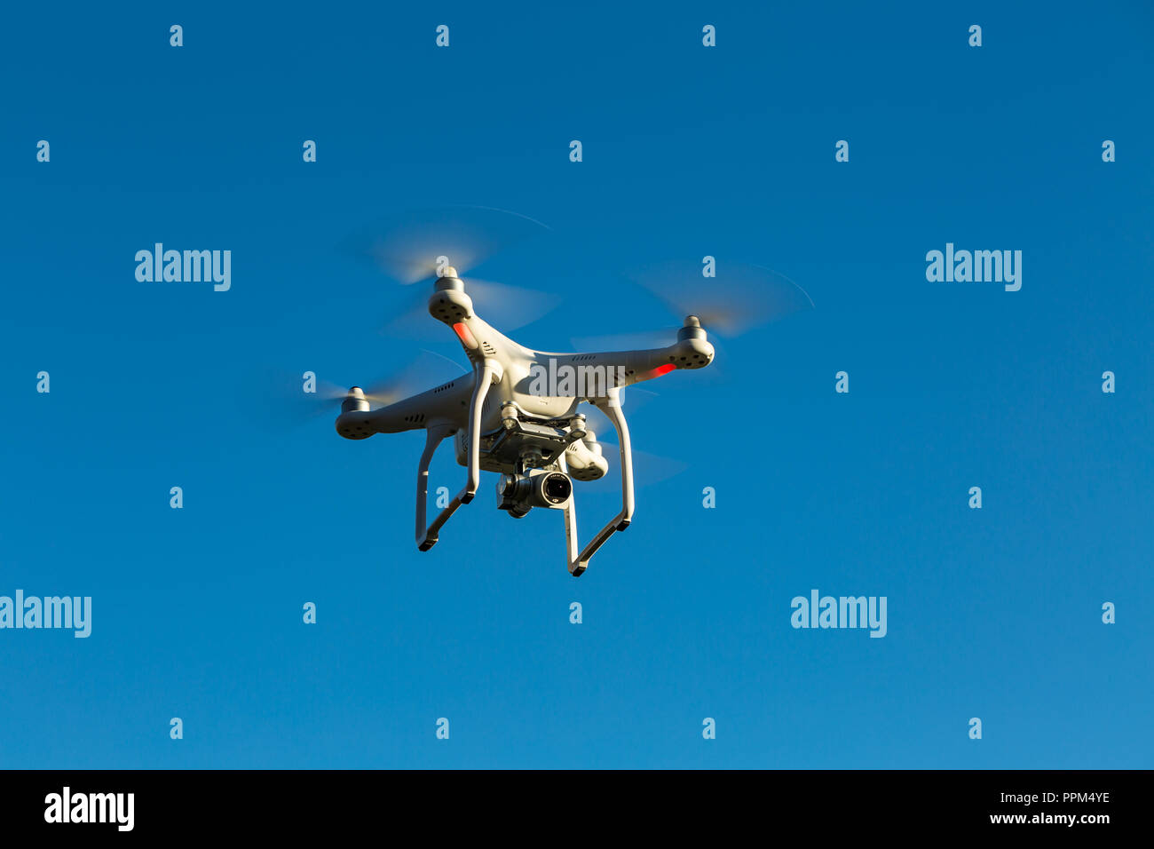Niedernhausen, Germany, December 29th, 2016, Quadcopter drone DJI Phantom flying into blue sky Stock Photo