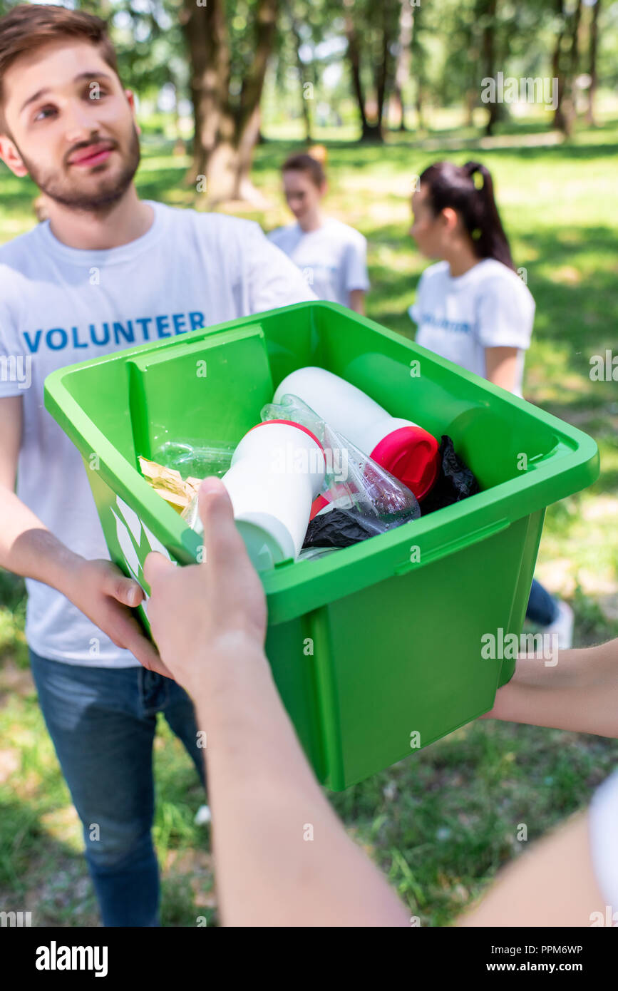 male volunteers with green recycling box in park Stock Photo Alamy