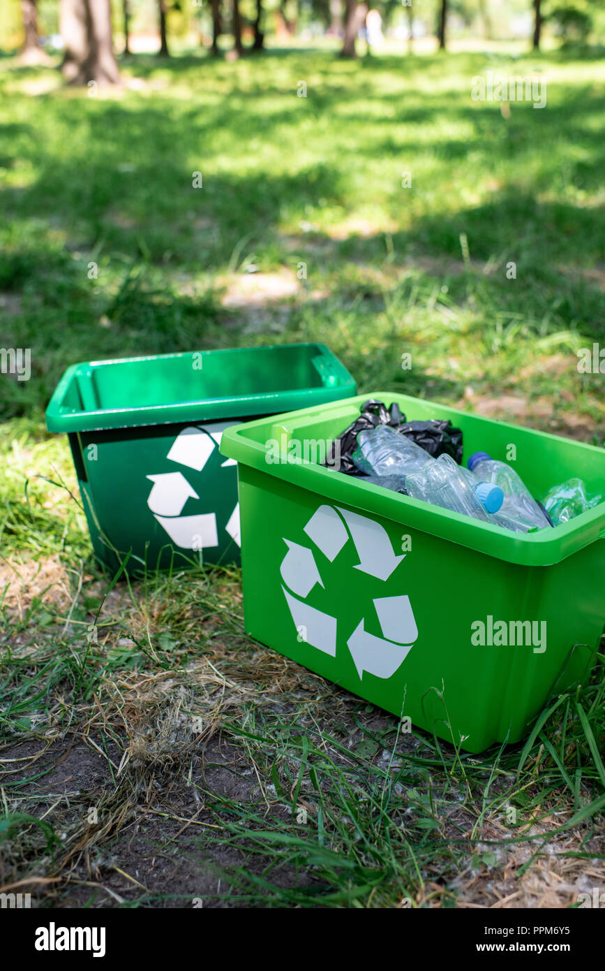green recycling boxes with trash standing on grass Stock Photo Alamy