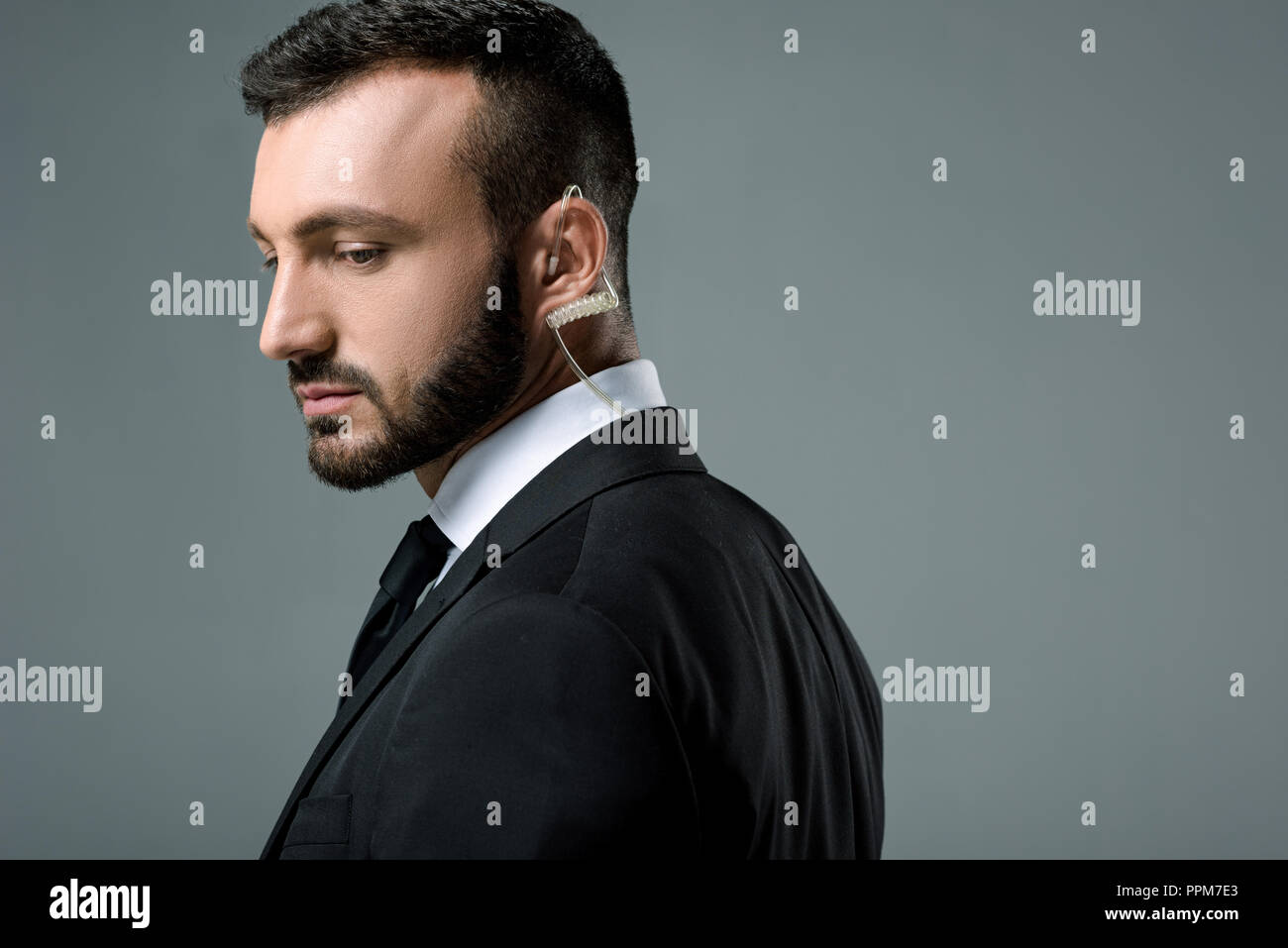 side view of handsome security guard with security earpiece isolated on grey Stock Photo
