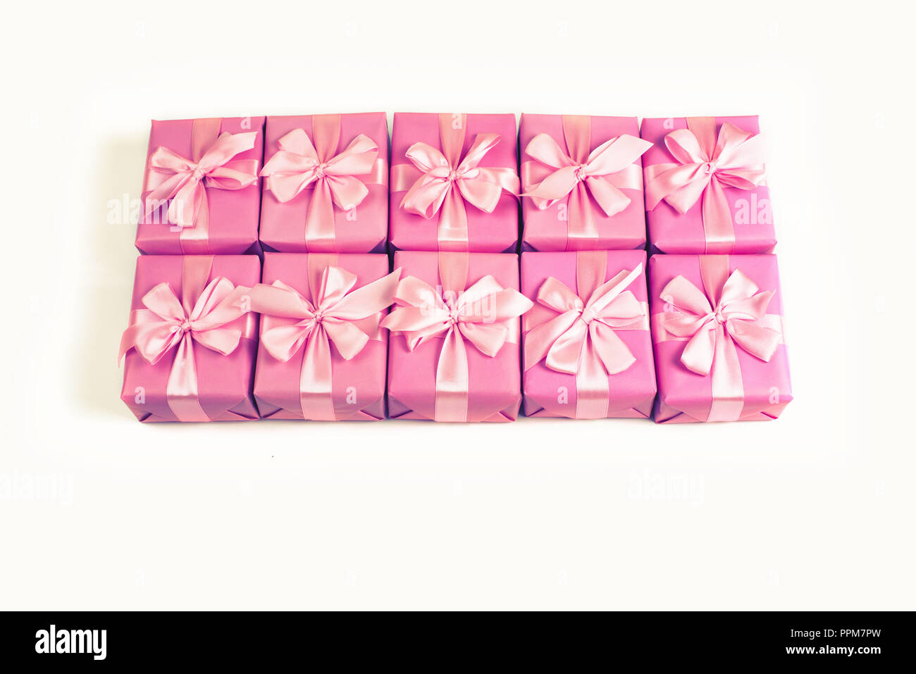 Rows of boxes with gifts decoration ribbon satin bow pink. A top view of Flat lay toning. Stock Photo