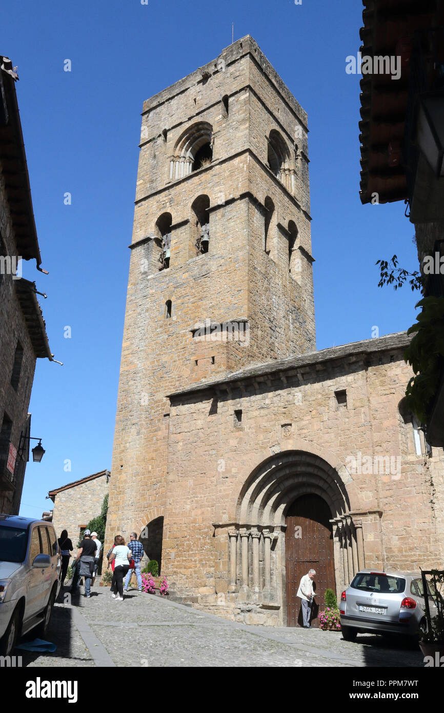 The stone romaneque Holy Mary Church (Iglesia de Santa Maria) with its bell tower in Ainsa, a small rural village in the Spanish Aragonese Pyrenees Stock Photo