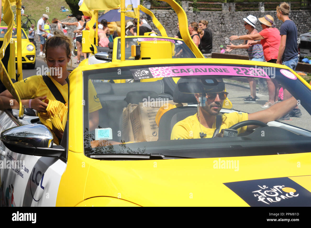 The yellow Le Crédit Lyonnais cars throwing free gifts during the 2018 Tour de France 17th stage in Soulan, French Pyrenees, and supporters. Stock Photo