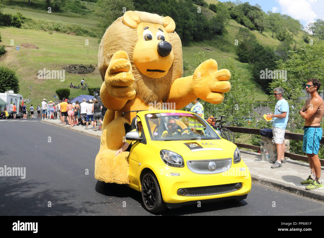 The yellow Le Crédit Lyonnais cars with the typical lion mascot throwing free gifts during the 2018 Tour de France 17th stage in Soulan, Pyrenees. Stock Photo