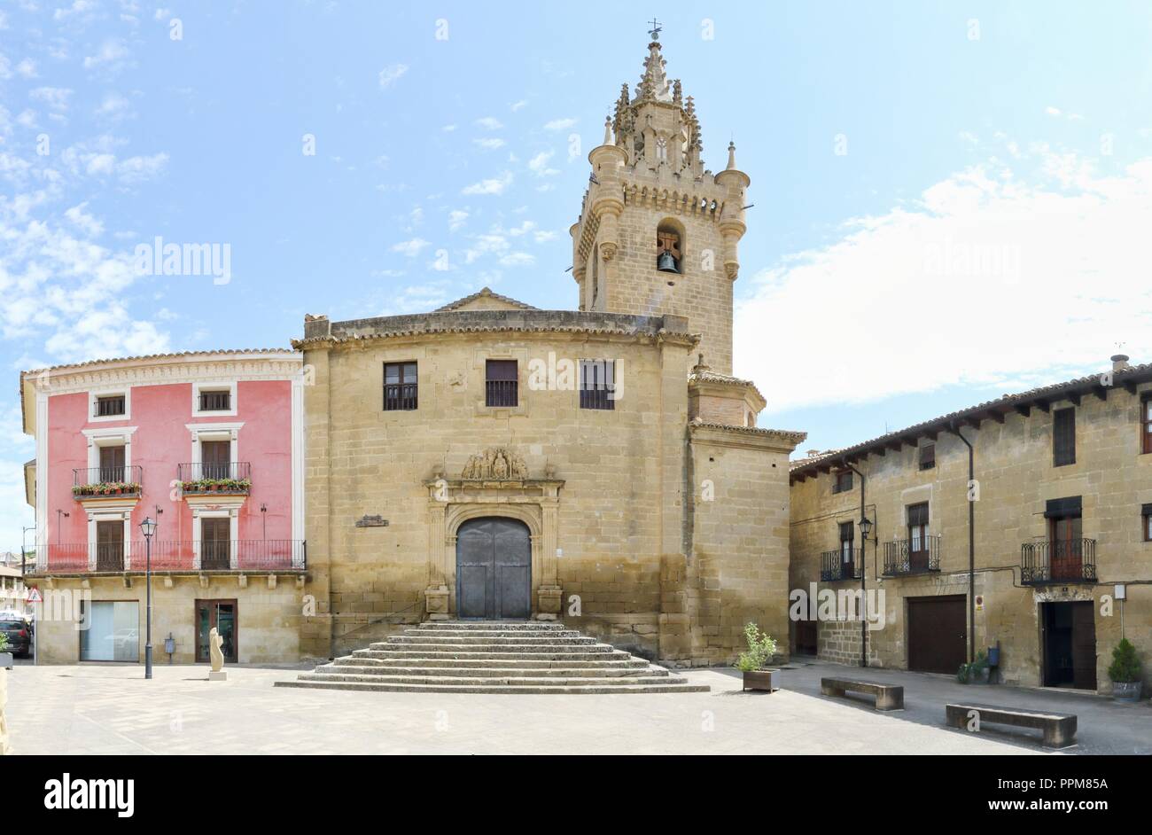 The brick made Holy Mary Church (Iglesia de Santa Maria) with bell tower and Plaza del Olmo square in front of it, in Uncastillo, Spain Stock Photo