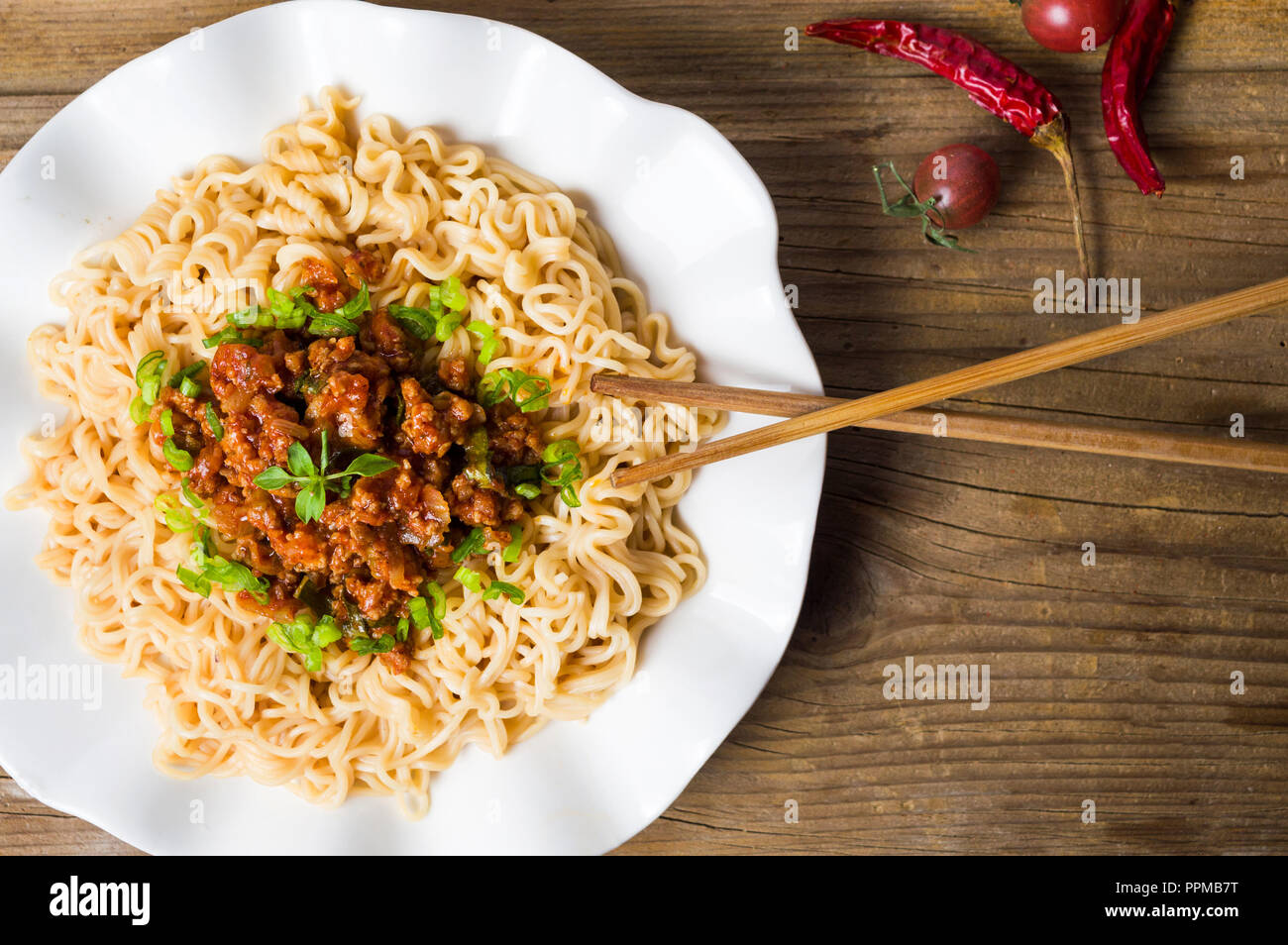 Pasta with pork and tomato served on white plate Stock Photo
