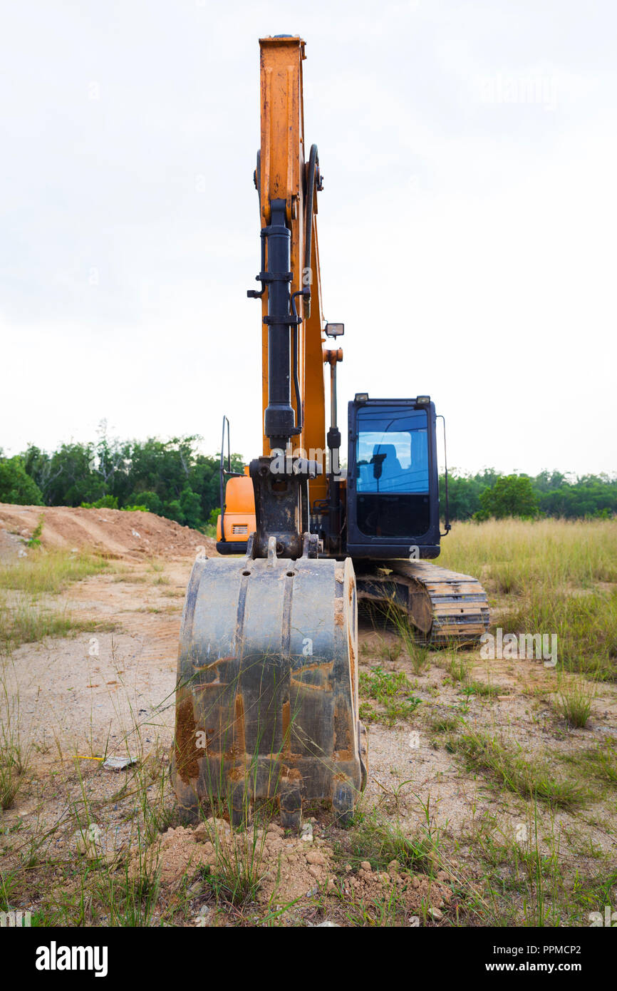 Yellow construction transport excavator digging earth outdoors Stock