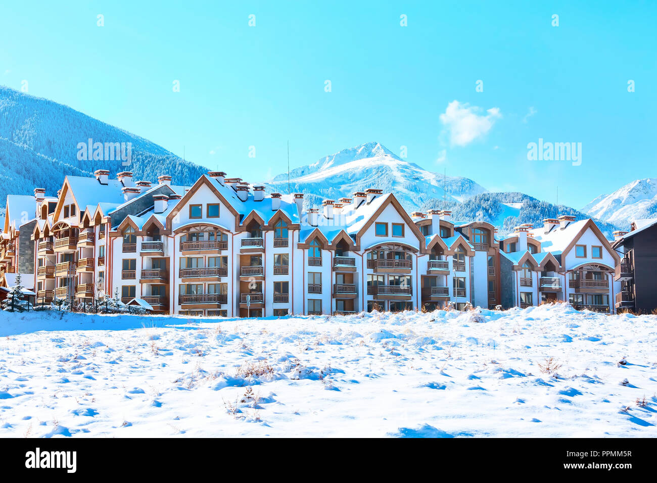 Wooden chalet, houses and snow mountains landscape panorama in