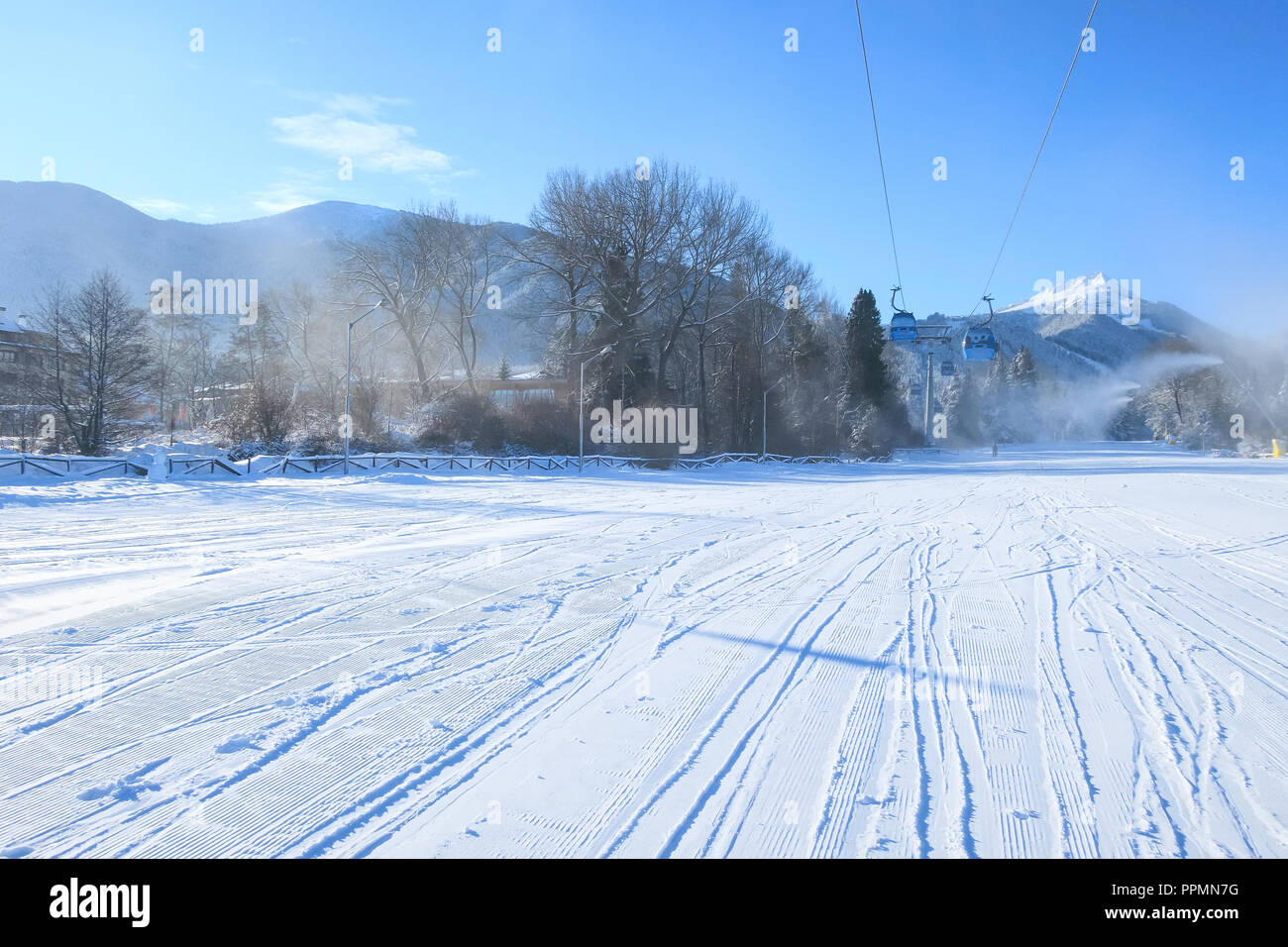 ski resort panorama with ski lift cabin, slope and snow mountains, Bulgaria Stock Photo