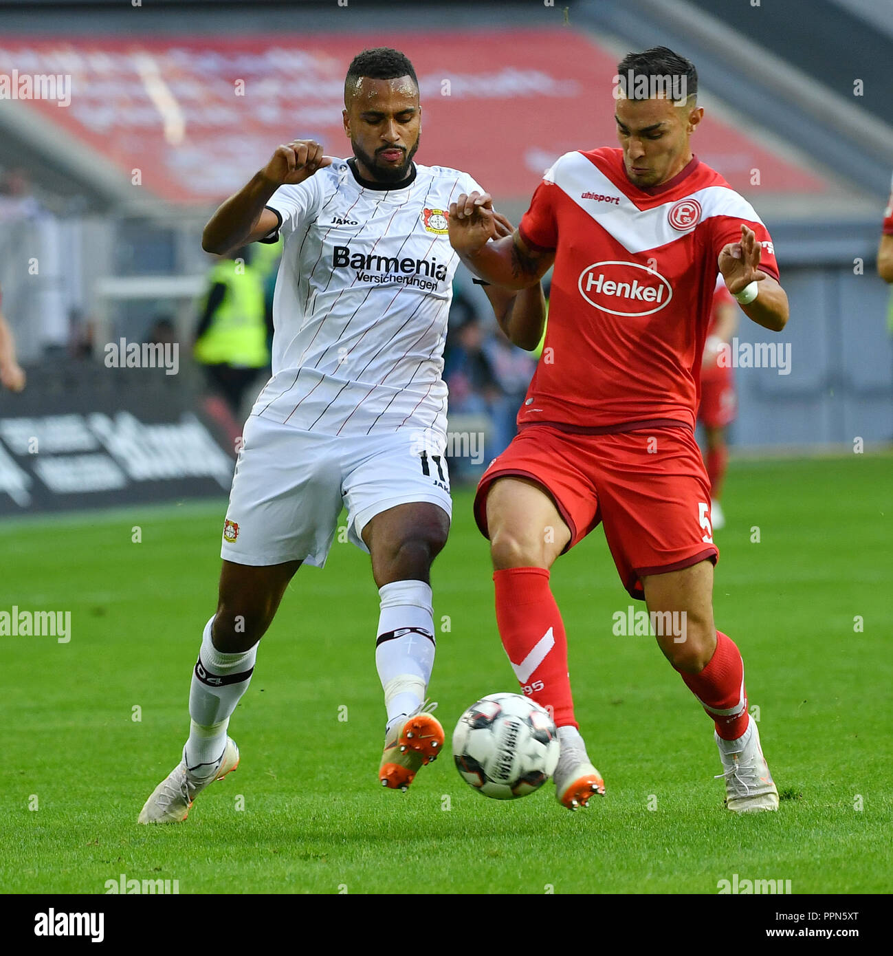 Dusseldorf. 26th Sep, 2018. Kaan Ayhan (R) of Fortuna Dusseldorf and Isaac  Kies Thelin of Bayer Leverkusen battle for the ball during the Bundesliga  match between Fortuna Duesseldorf and Bayer Leverkusen at