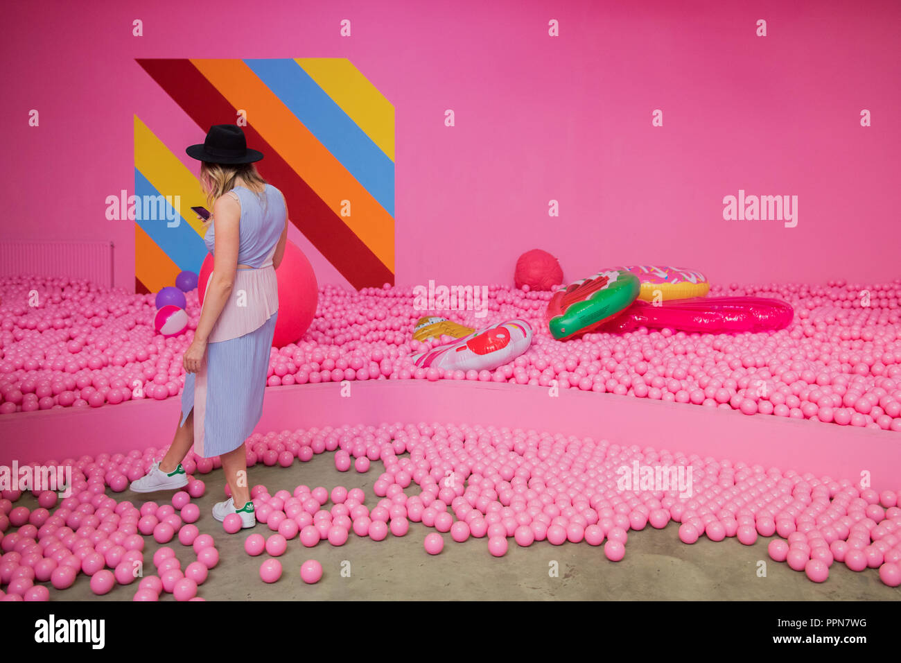 Cologne, Germany. 27th Sep 2018. 27 September 2018, North Rhine-Westphalia,  Cologne: A visitor of the Supercandy Pop-Up Museum takes pictures in a ball  bath. Until 30.12.2018 the 20 walk-in installations can be