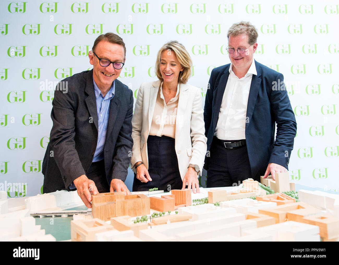 27 September 2018, Hamburg: Peter St. John, architect of Caruso St. John from London (l-r), Julia Jäkel, CEO of Gruner + Jahr and Franz-Josef Höing, Chief Building Director of the Urban Development and Housing Authority, look at a wooden model of the winning design for the new Gruner + Jahr publishing building. The publishing house gets a new company headquarters in HafenCity. Photo: Daniel Bockwoldt/dpa Stock Photo