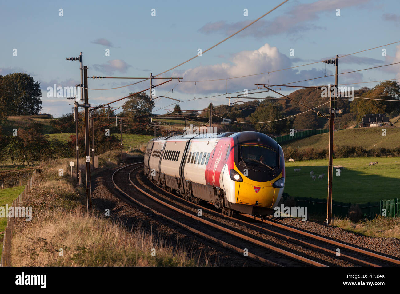 A Virgin Trains west coast pendolino on the west coast main line in Lancashire tilting as it takes a Stock Photo Alamy
