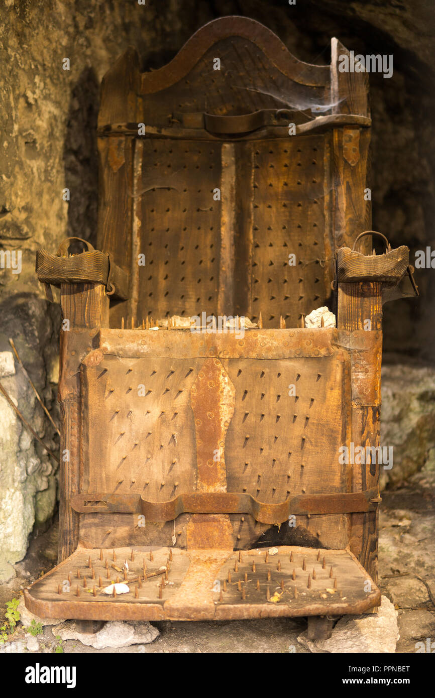 august 2018, ogrodzieniec, poland: wooden chair with nails for witches used to extreme torture Stock Photo