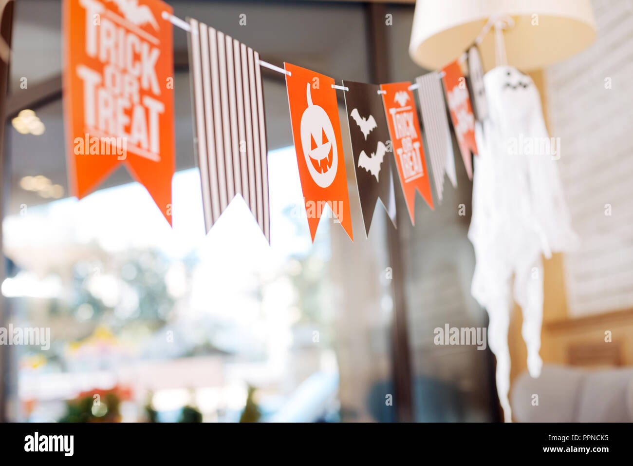 Nice bright decorations with sign trick or treat lying in light spacious event hall Stock Photo