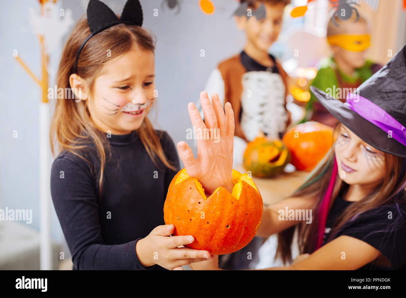 Two beautiful dark-haired girls wearing Halloween costumes eating scary ...