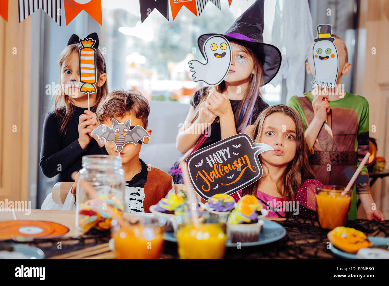 Boys and girls wearing costumes holding pictures and signs devoted to Halloween Stock Photo