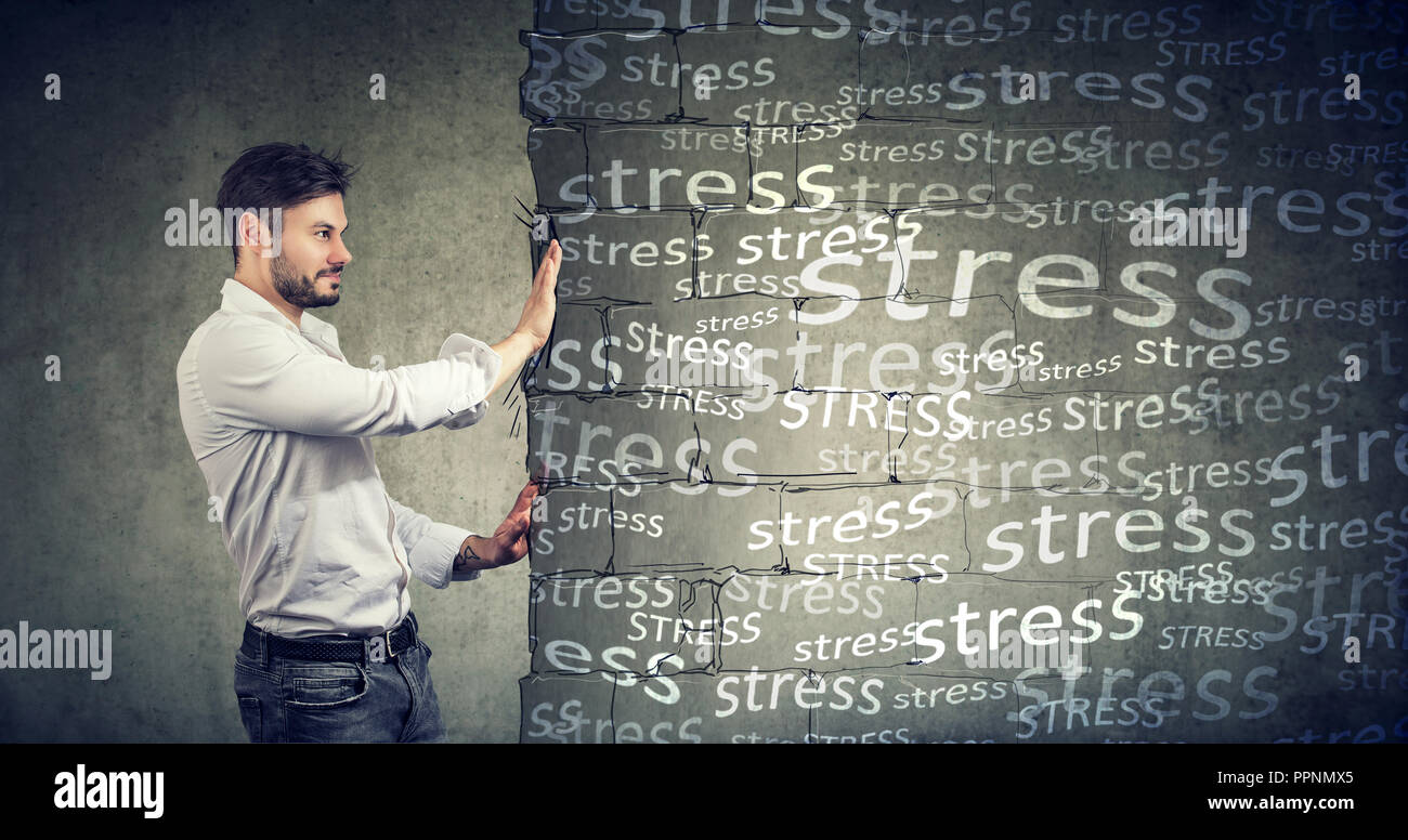 Side view of a man pushing away block wall with stress willing to have happy life. Stock Photo