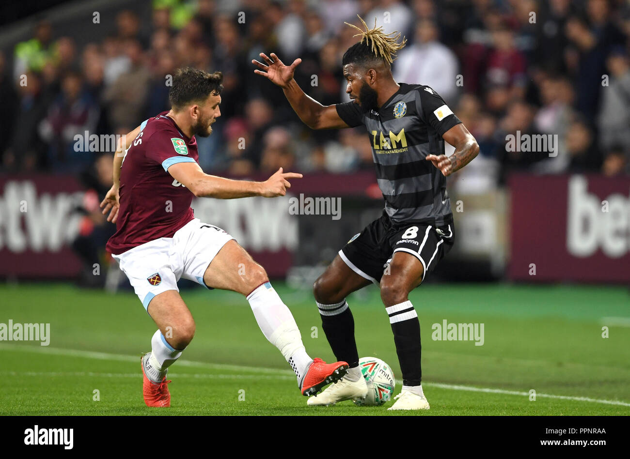 West Ham United's Robert Snodgrass (left) and Macclesfield Town's Tyrone Marsh battle for the ball during the Carabao Cup, Third Round match at London Stadium. Stock Photo