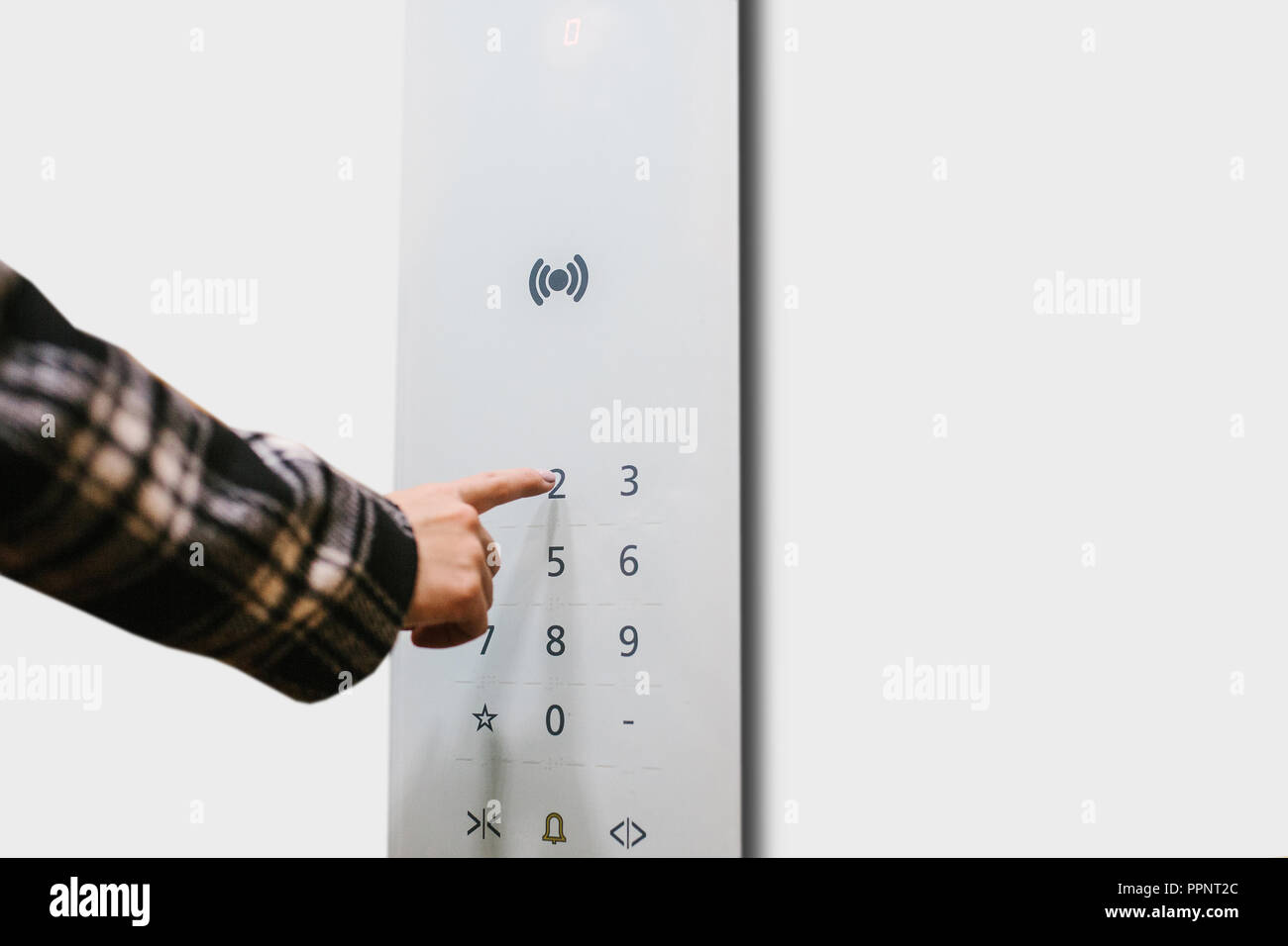Close-up of a girl pressing a touch button in a modern elevator. Stock Photo